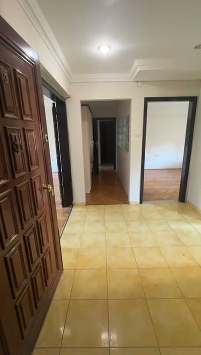 Sarı-krem seramik, koyu kahverengi panelli ahşap kapılar. Aynı seramik koridor boyunca uzanıyor.